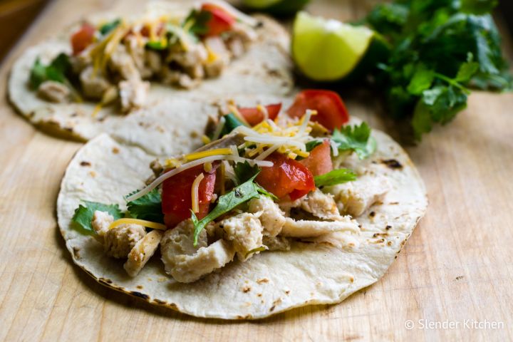 Stovetop shredded chicken taco filling served in corn tortillas with cooked peppers, onions, and cheese.