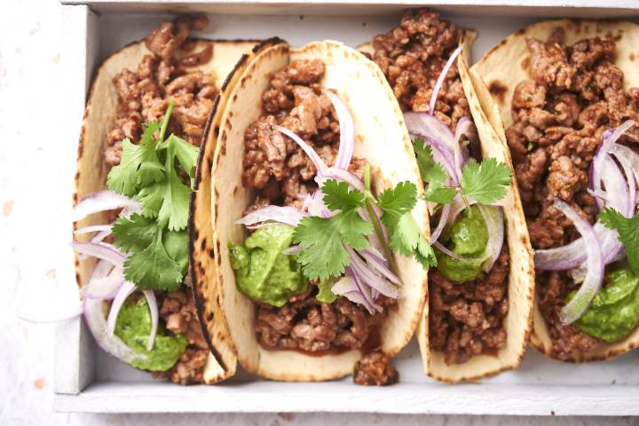 Taco meat served in crispy tortillas with cilantor, onions, and guacamole.