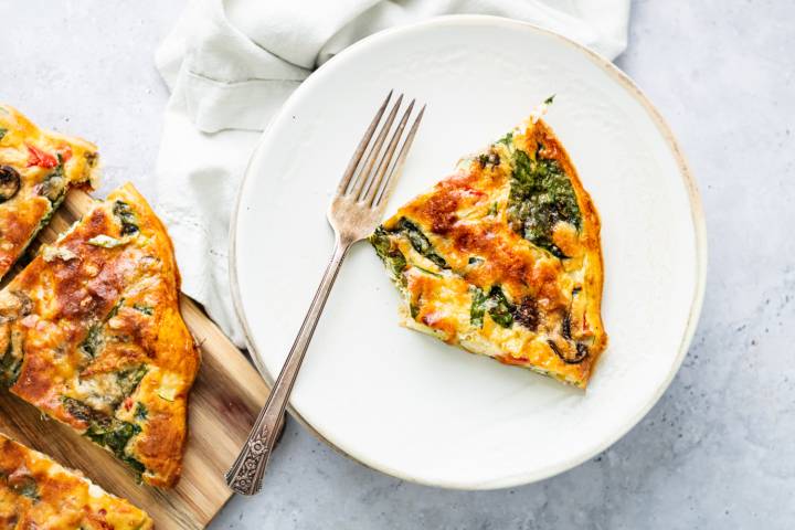 Vegetable frittata with tomatoes, spinach, mushrooms, green onions, and parmesan cheese.