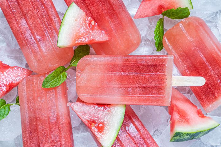 Watermelon popsicles with fresh watermelon and honey with ice cubes and fresh watermelon slices.