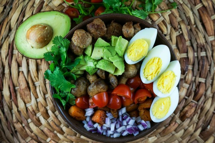 Breakfast salad with sausage, boiled eggs, avocado, butternut squash, and mushrooms.