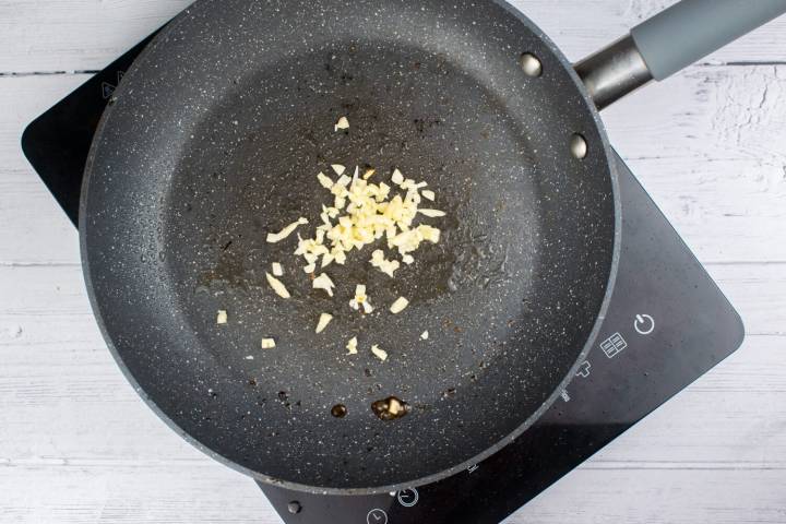 Garlic being cooked in a pan.