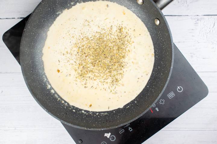 Garlic cream sauce for mushroom chicken in a pan.