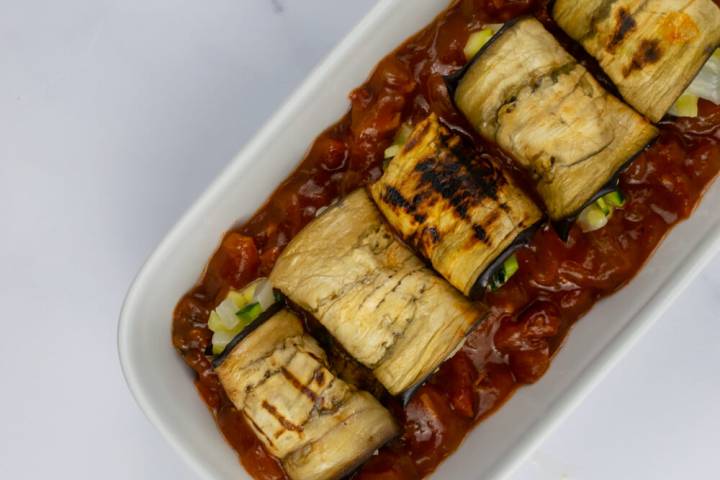 Eggplant rollatini in a dish with marinara saiuce.
