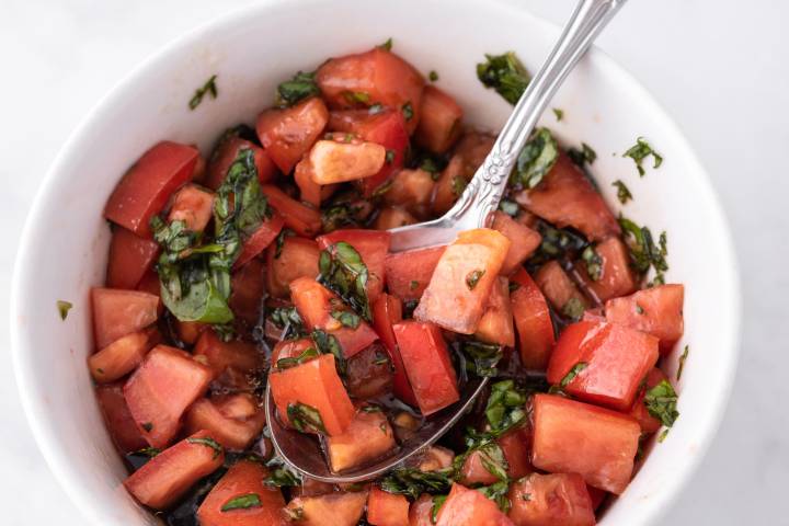 Tomato basil salsa in a bowl with a spoon.