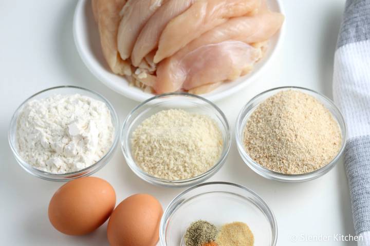 Ingredients including chicken, eggs, breadcrumbs, and flour to make chicken tenders.