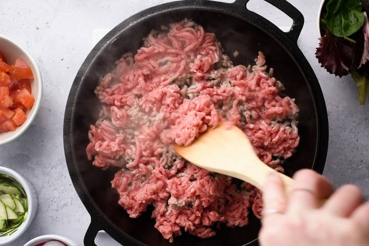 Ground beef being browned in a skillet.