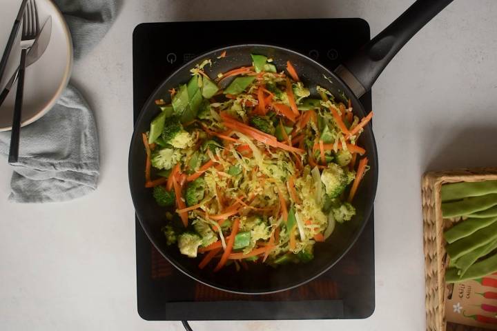 Vegetables being cooked in a pan for a stir fry.
