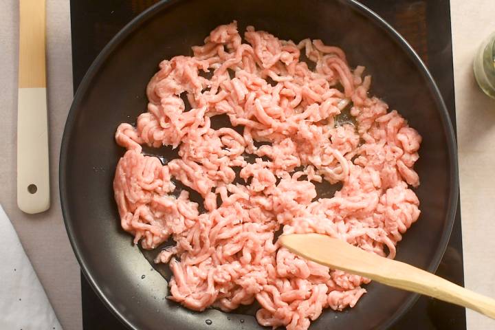 Ground turkey being stir fried with Chinese 5 spice in a pan.