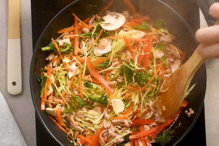 Turkey, fresh vegetables, and soy sauce cooking in a pan.