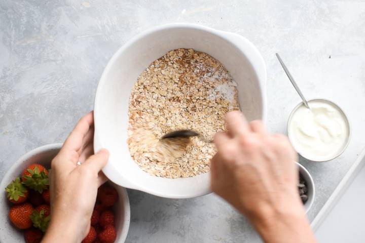 Rolled oats, flaxseed meal, cinnamon, baking powder, and salt in a bowl.