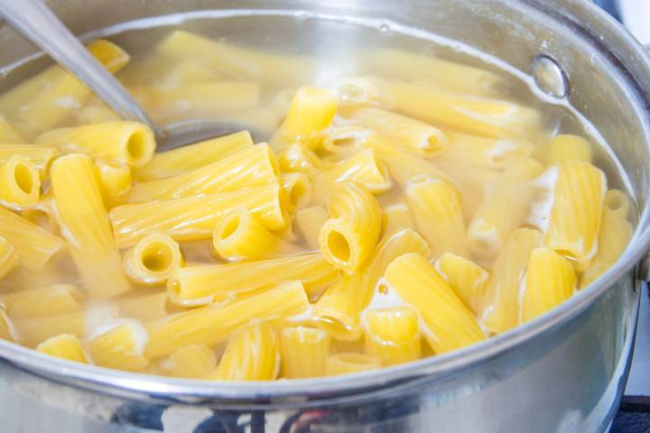 Ziti cooking in a pot of boiling water.
