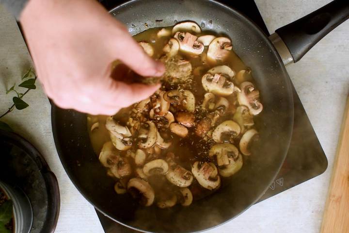 Mushrooms and garlic cooking in a skillet.