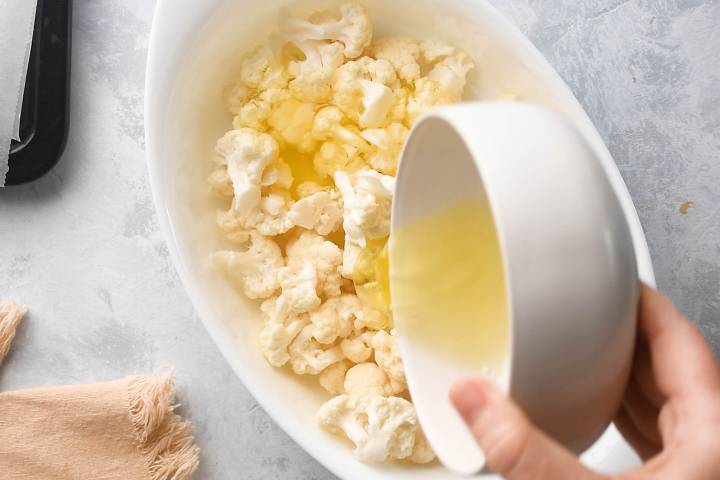 Cauliflower florets being tossed with egg whites.