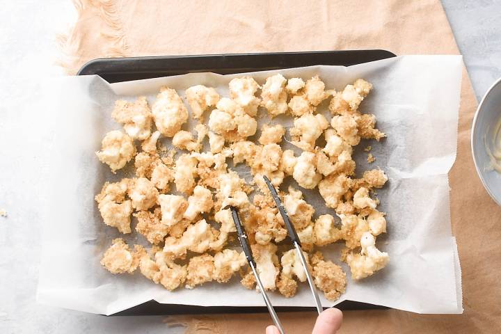 Breaded cauliflower on a baking sheet.