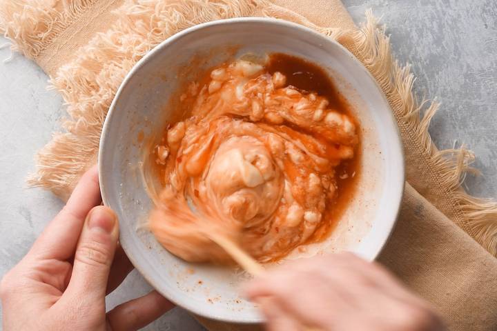 Bang bang sauce being made with mayonnaise, chili sauce, Sriracha, and lime juice.