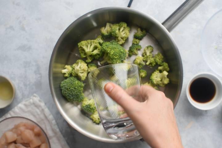 Broccoli and water in a hot skillet.