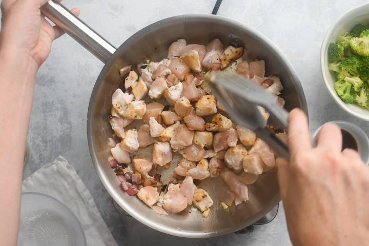Chicken breast cooking in a pan.