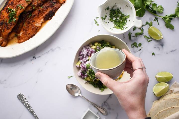 Lime juice being added to mango and avocado salsa.