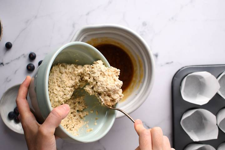 Oatmeal batter being poured into a mixture of honey, applesauce, and eggs.
