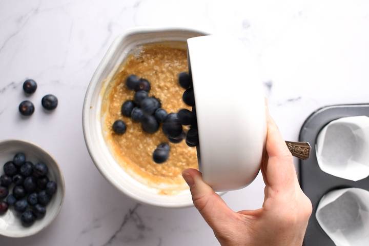 Blueberries being folded into oatmeal batter.