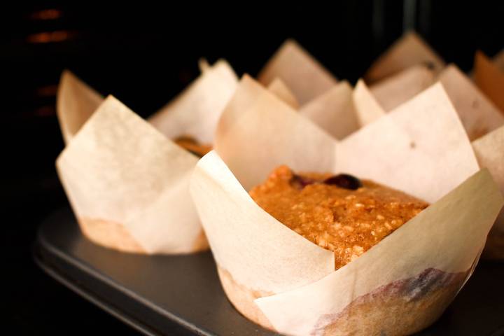 Blueberry oatmeal muffins in a baking dish with parchment paper liners.