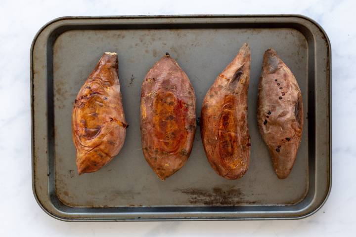 Baked sweet potatoes on a baking sheet.