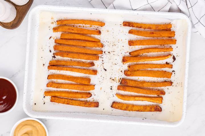 Crispy butternut squash fries on a baking sheet.