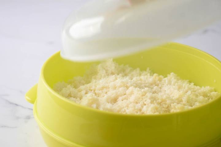 Cauliflower rice in a microwave container.