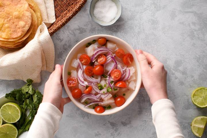 Fish ceviche in a bowl with tomatoes and red onions.