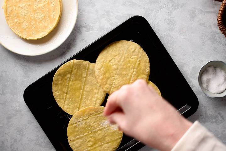 Corn tortillas on a baking sheet to make tostada shells.