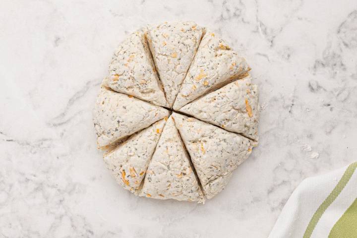 Cheddar biscuit dough cut into eight equal triangles.