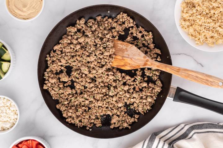 Kofta spices added to ground chicken and cooking in a skillet.
