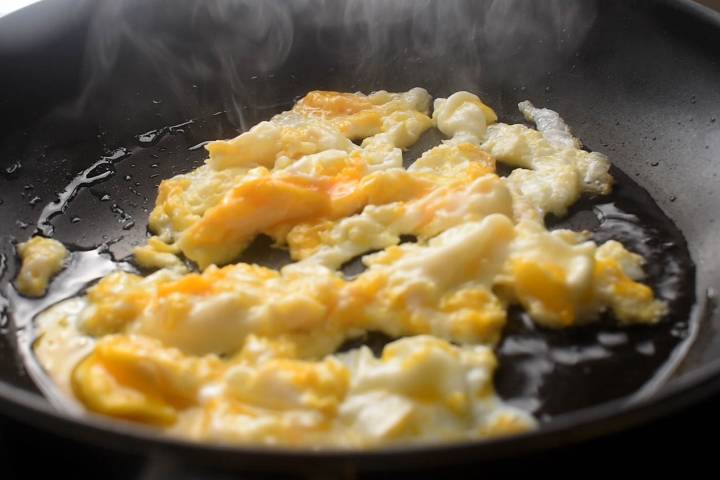 Eggs being scrambled in a skillet.