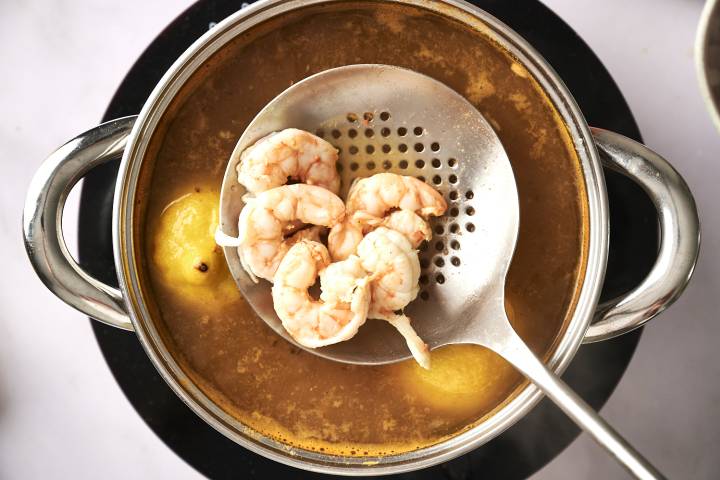 A top-down shot of a bowl with chopped bell peppers, avocado, corn, and cilantro.