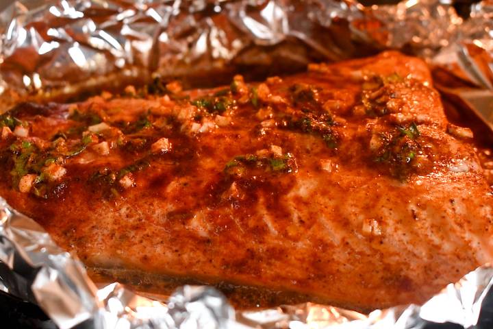 Cilantro lime salmon baking in the oven wrapped in foil.