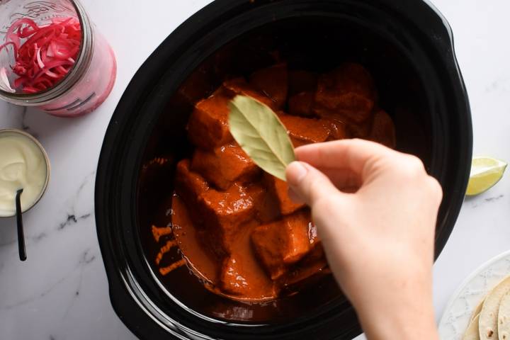 Pork shoulder in achiote citrus sauce in a slow cooker.