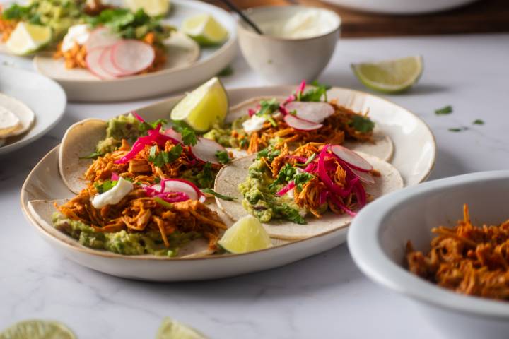 Taco filled with cochinita pibil, onions, cilantro, and radishes. 