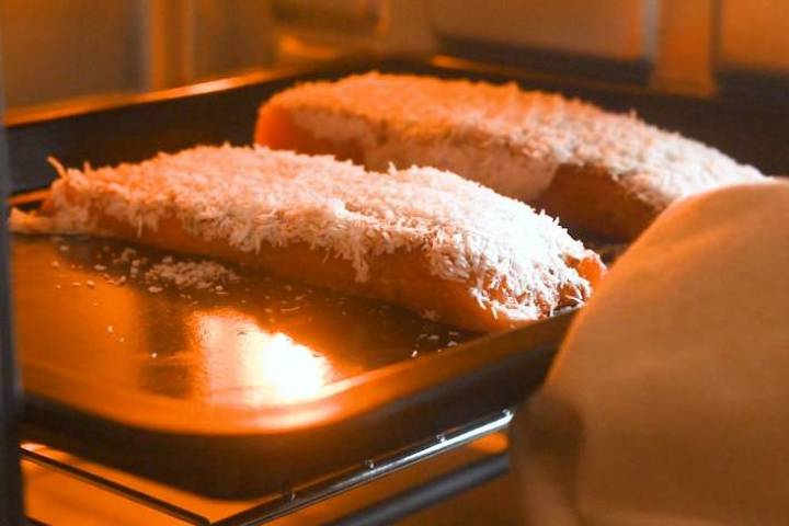 Coconut crusted salmon cooking on a rack in the oven.
