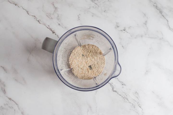 Rolled oats being blended into flour in a blender.