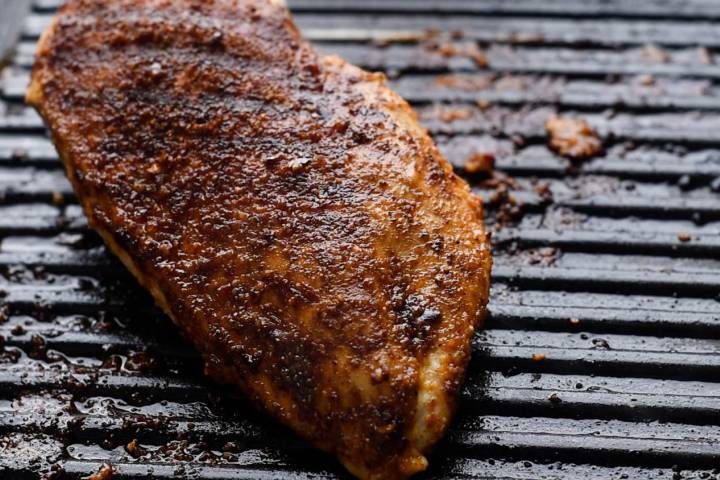 Cumin chicken breasts grilling on a grill pan.