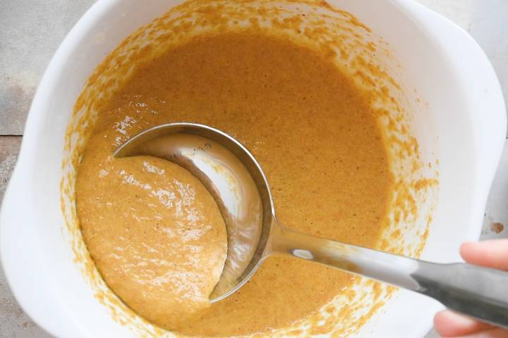 Flax seed pancake batter in a bowl with a ladle.