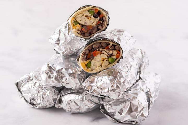 Wrapped freezer breakfast burritos in a stack.