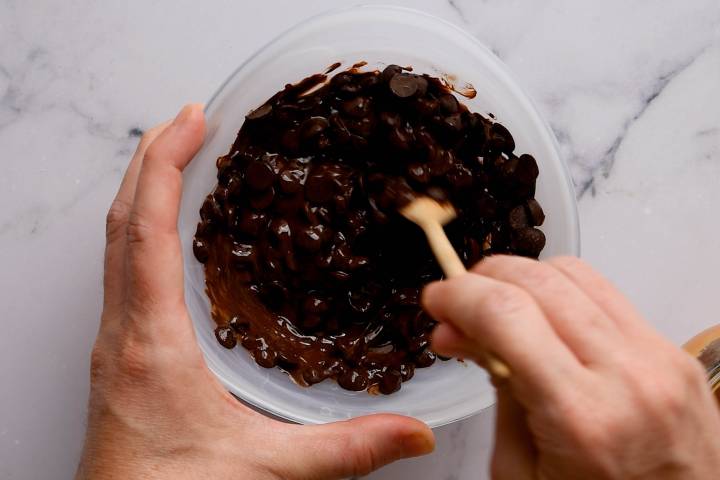 Melted chocolate chips being stirred in a bowl.