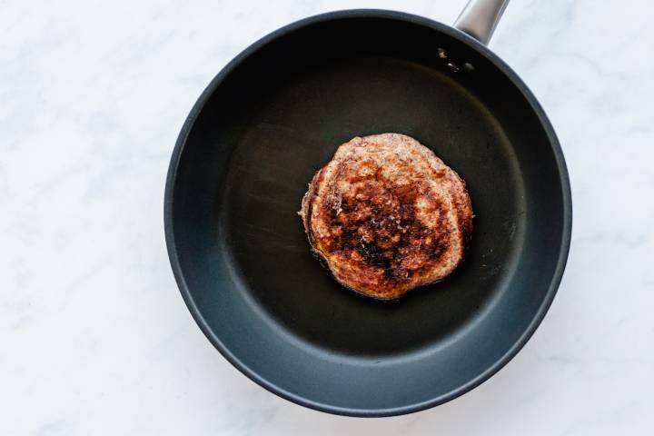Greek yogurt and flaxseed pancake cooking in a skillet.