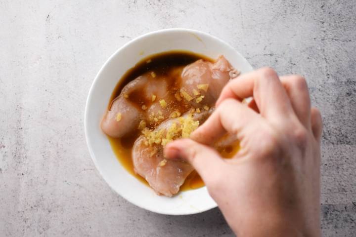 Chicken breast marinating in soy sauce, orange juice, honey, ginger, and garlic.
