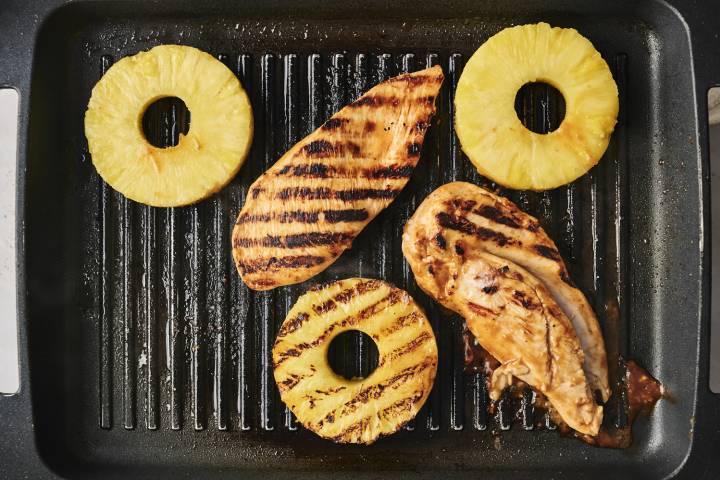 Chicken breast and pineapple on a grill pan.