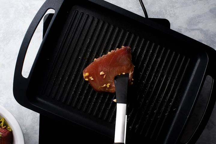 Ahi tuna being cooked on a grill pan.