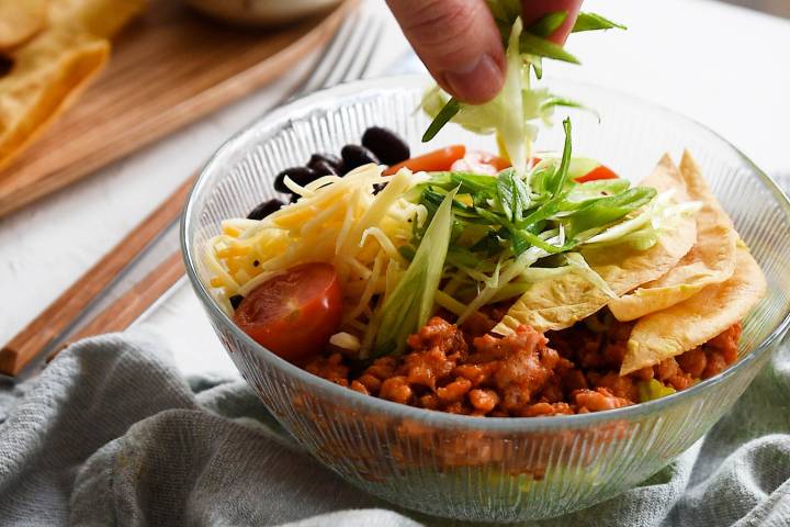 Turkey taco salad with green onions being sprinkled on top.