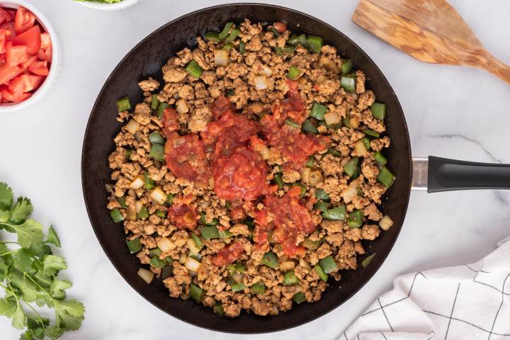 Sala adding to ground turkey meat with peppers and onions.